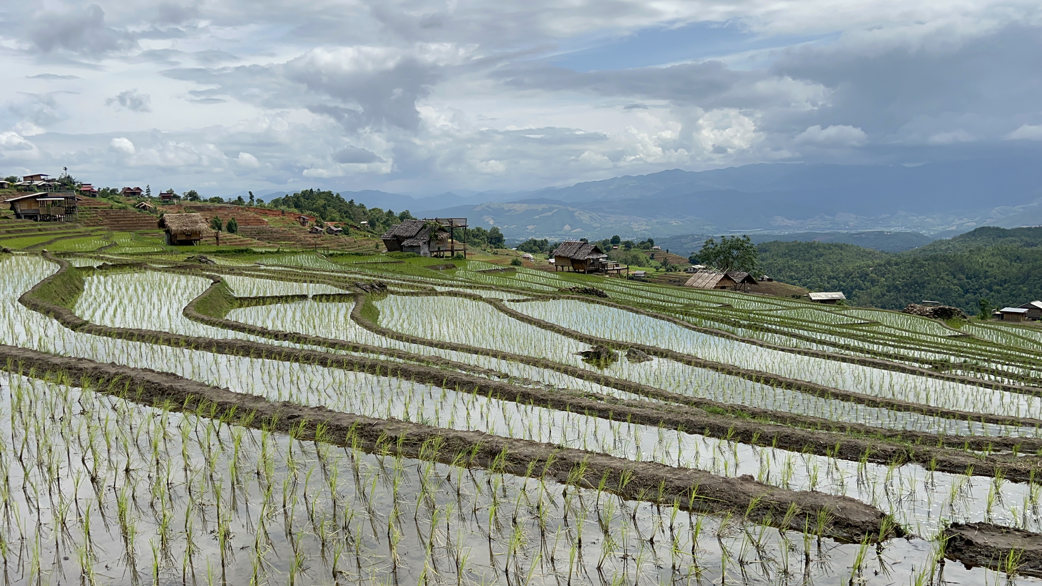 Rice terraces and mountain views in northern Thailand under dramatic cloudy skies